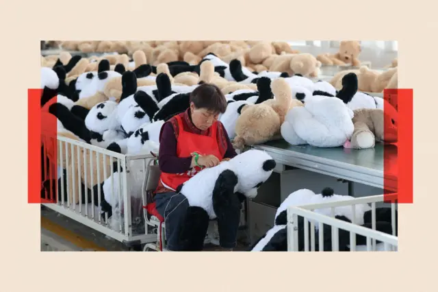 Una mujer en una fábrica cose pandas de peluche
