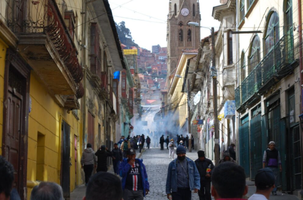 Los manifestantes se retiran mientras gases lacrimógenos descienden hacia las calles comerciales del centro de La Paz | Joseph Bouchard