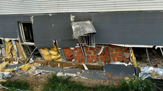 Escombros de la planta baja de un edificio. Se ve acero torcido y bloques en medio de la estructura.